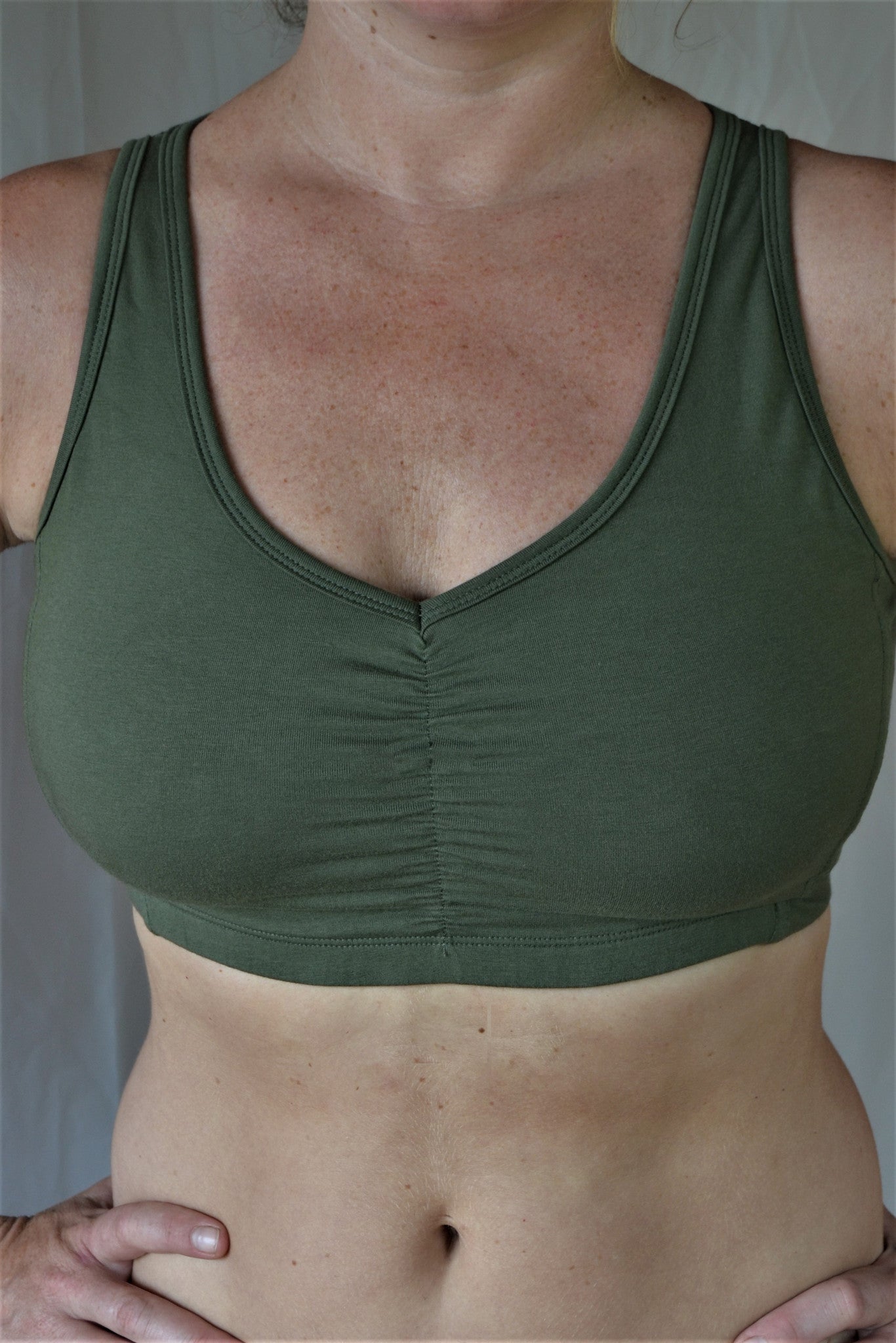Front view Sage green Sports Bra has scrunching between the breasts, wide straps and full coverage. Made for the fuller bust.
