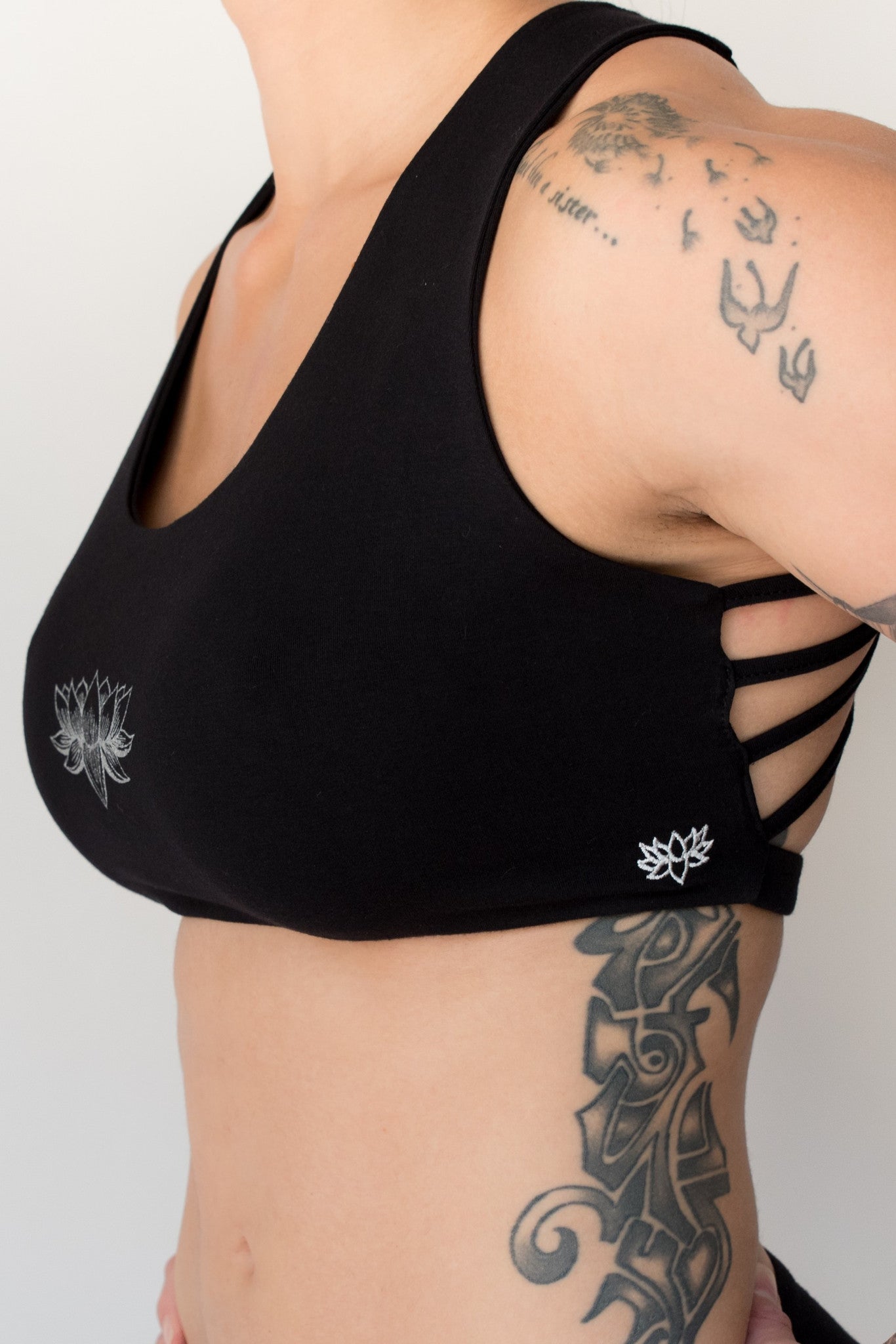 Soft, comfortable and super cute black sports bra with silver Lotus Flower design on front. Has enough support for down dog and other yoga poses with 4 criss cross straps in back 90% cotton 10% spandex