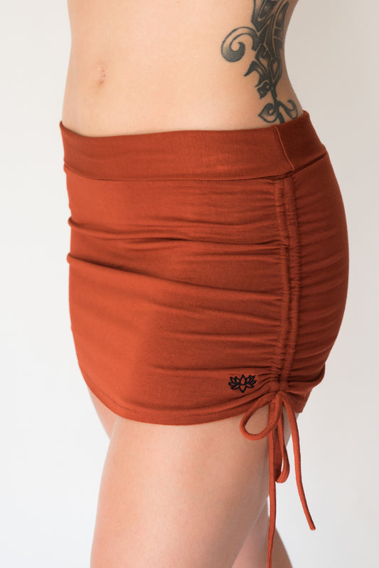 Cute little rust colored mini skirt with pull strings on the sides and fold over waist for adjustable fit. Soft and comfortable 90% rayon 10% cotton. Fits S/M