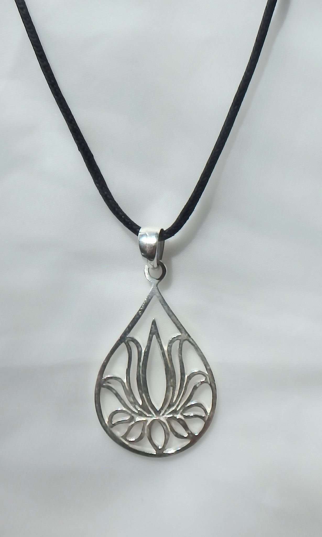 Teardrop shaped Lotus Flower pendant in silver 1.25" tall x 1" wide on black waxed cotton vegan friendly cord.