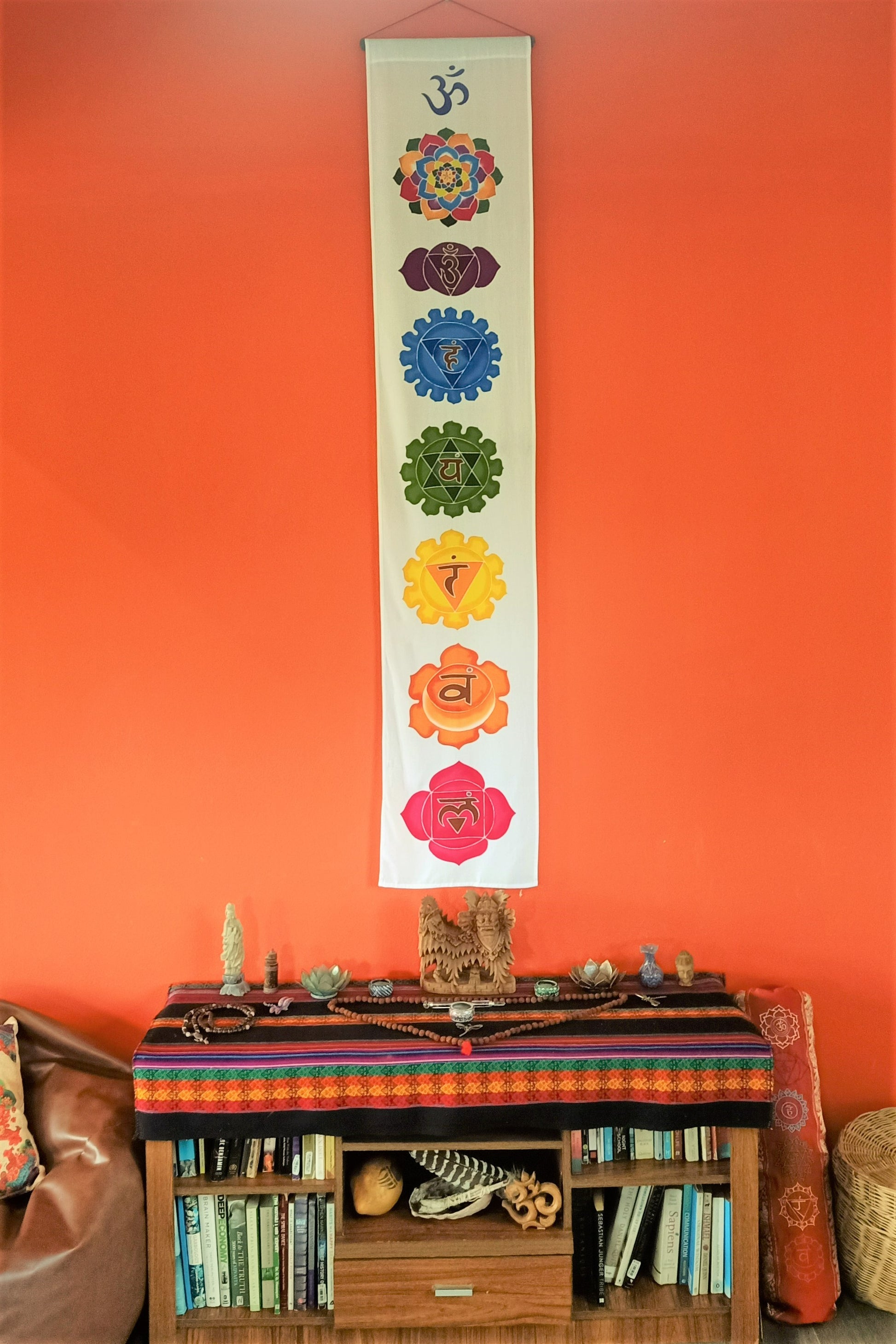 Vertical home decor wall hanging with white background and 7 rainbow colors chakra symbols. Handmade with wax and dye batik process on rayon fabric. Ready to hang.