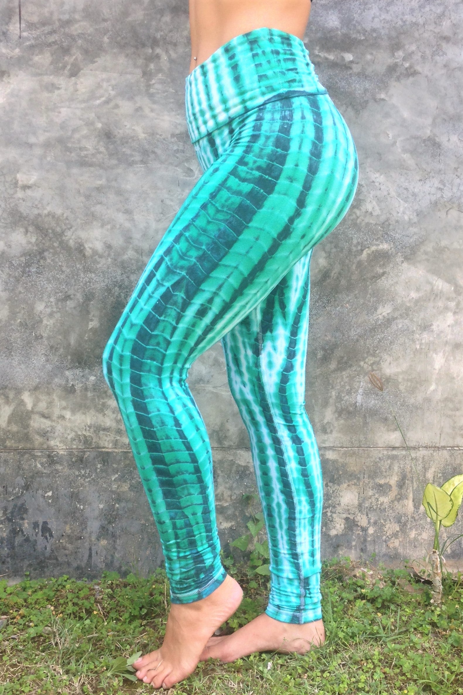 Long length yoga pants turquoise/teal tie dye. Fold over top for adjustable fit can be worn with higher waist or lower on the hips. 90% cotton 10% spandex. side view