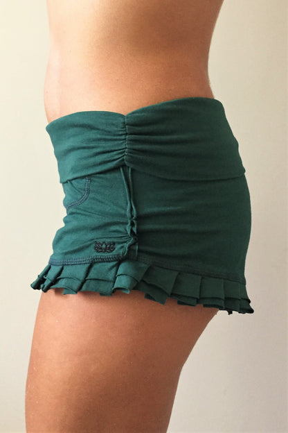 Side view of Forest green shorts with ruffles at bottom and fold over waist perfect for hot yoga or paired with your favorite top, also great for under a short dress. 