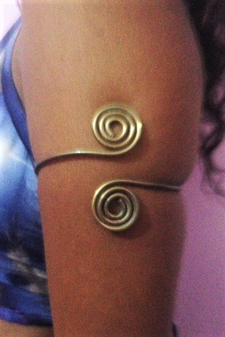 Double swirl, one on top and one on bottom from each side of brass armband. 